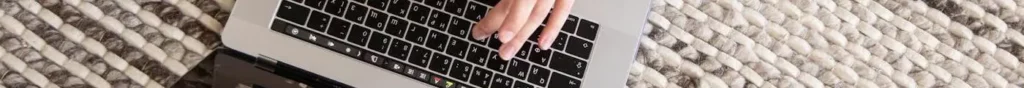 une main sur un clavier de laptop. Pour nous contacter, utilisez le formulaire en bas