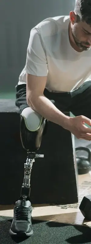 Un hommes assis avec une prothèse de jambe s'apprête à faire du sport. Qui sommes-nous, avenir, objectifs